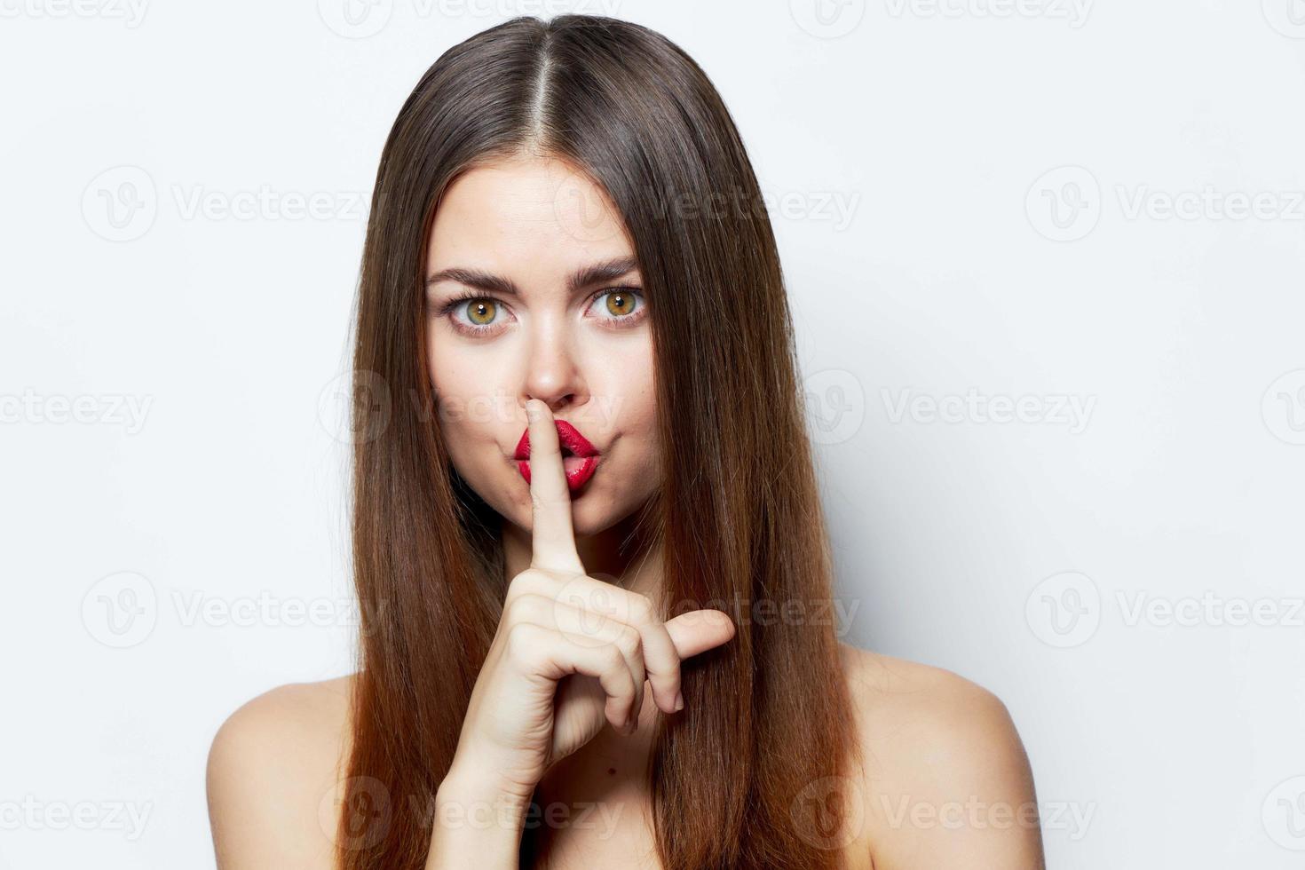 Girl holds his finger to his lips, top secret bare shoulders attractive look isolated background Copy space photo