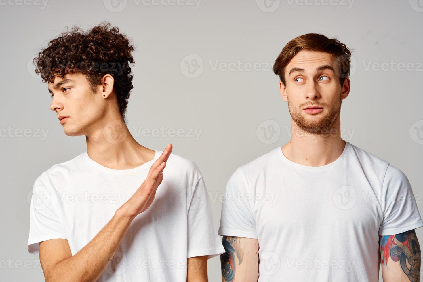 Two cheerful friends in t-shirts stand side by side isolated background joy photo