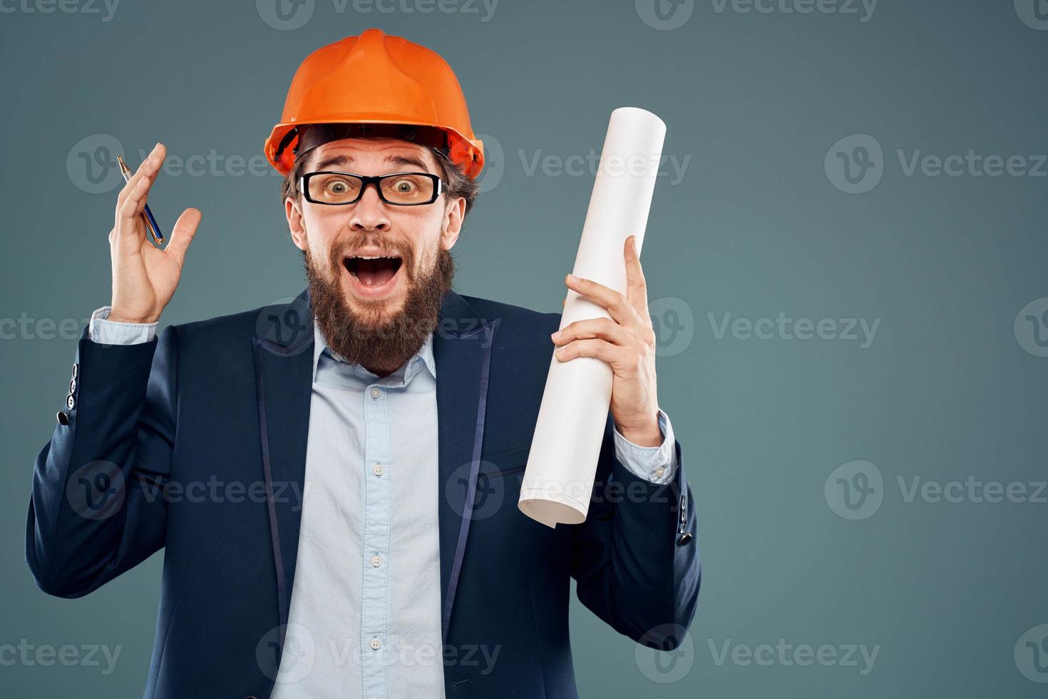 Male engineer wearing a suit in orange paint safety work drawings photo