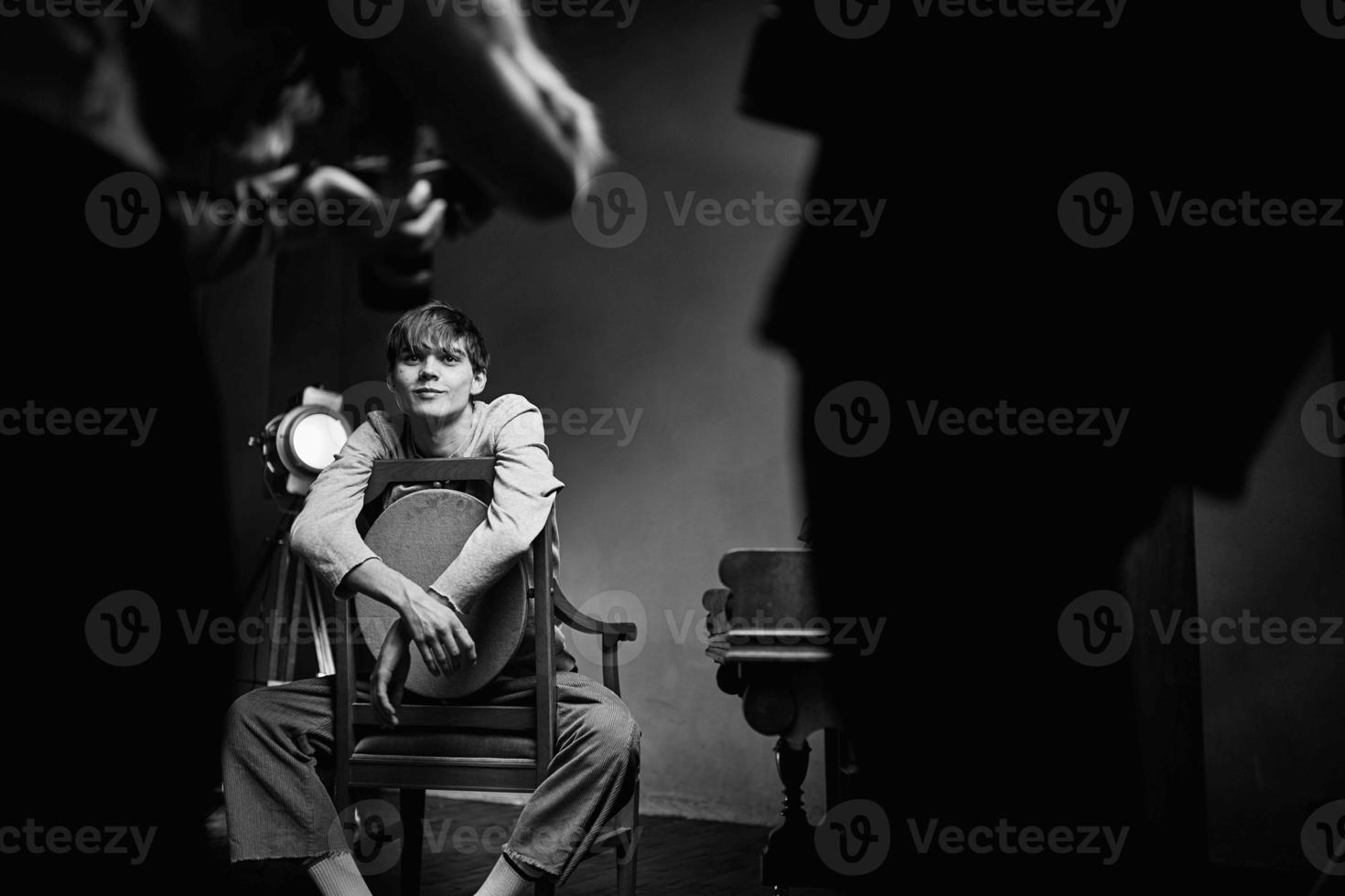 guy sitting on a chair next to the piano posing photo