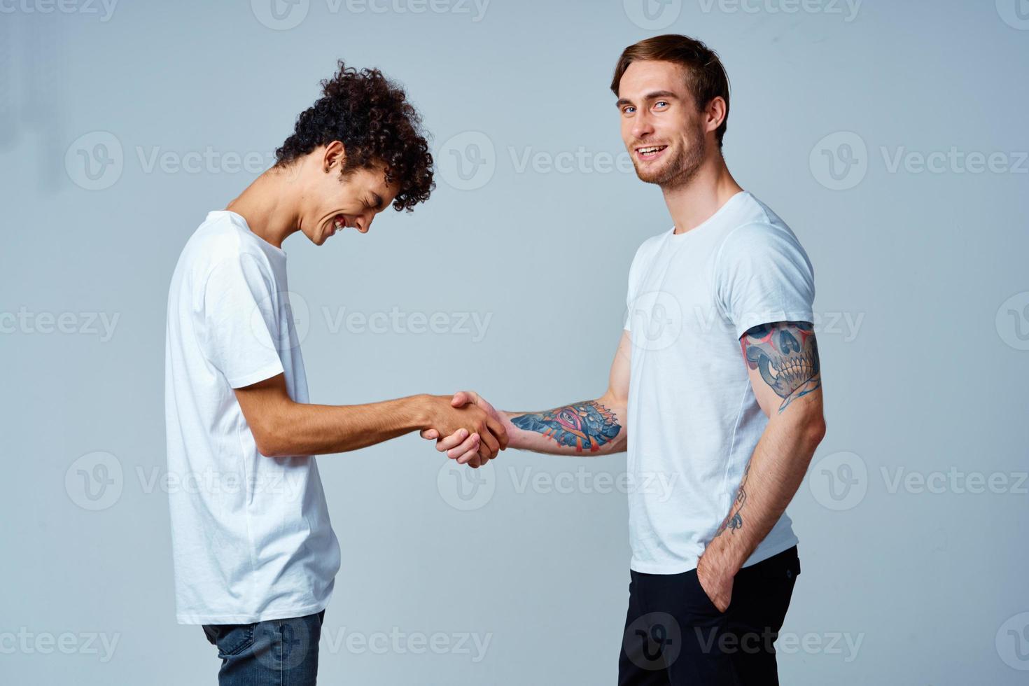 two friends hold hands in white t-shirts isolated background photo