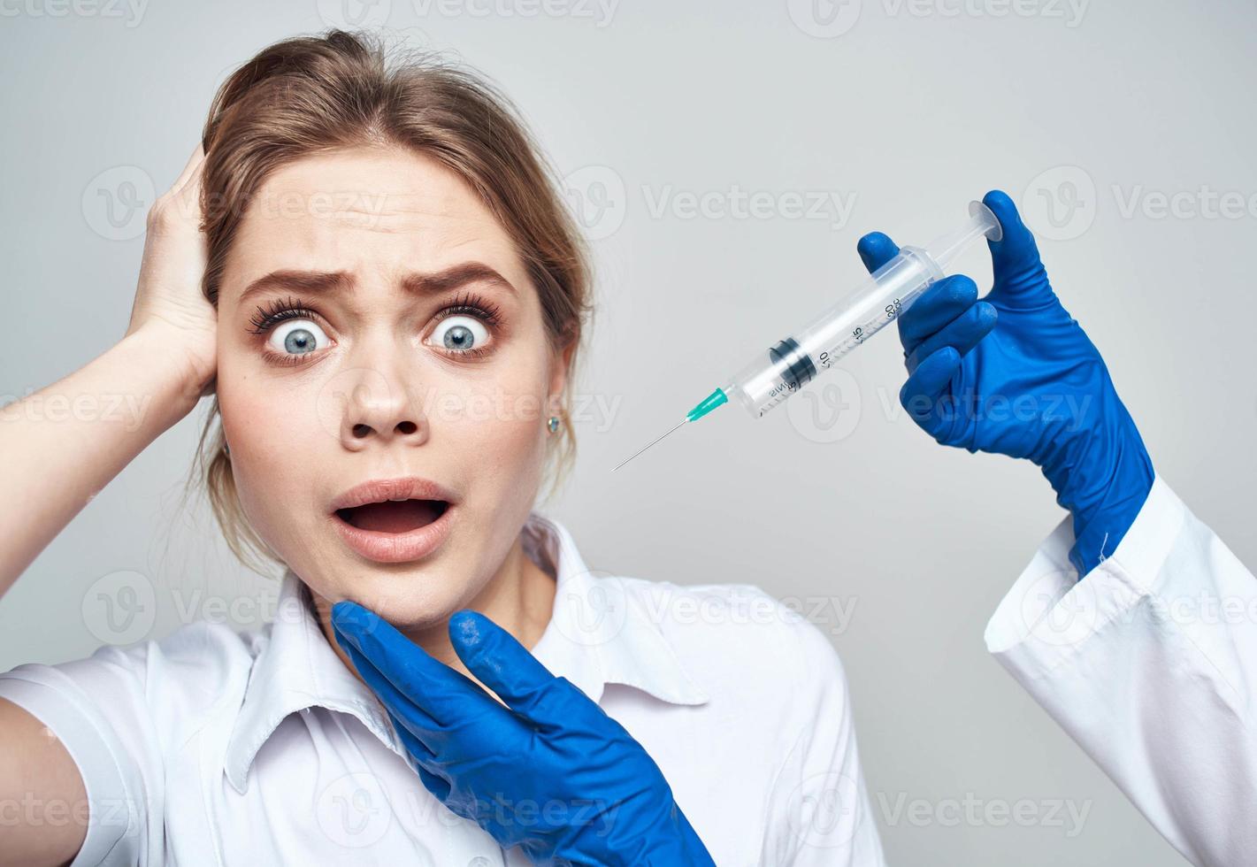 Scared woman and syringe in the hands of the doctor shock emotions model photo