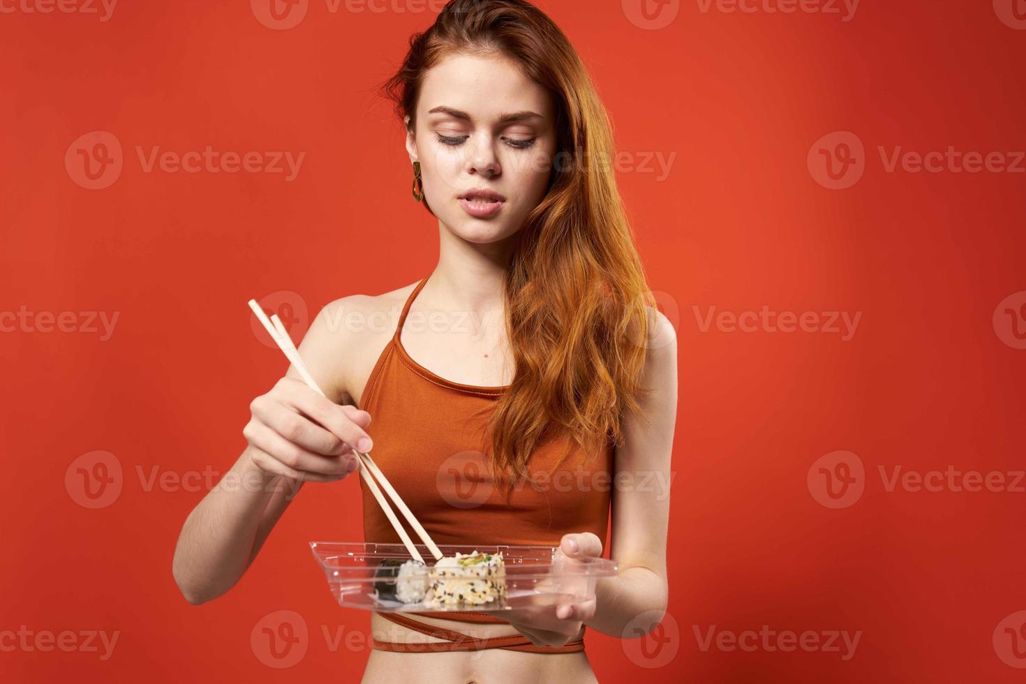 mujer en rojo t camisa palillos Sushi asiático comida foto