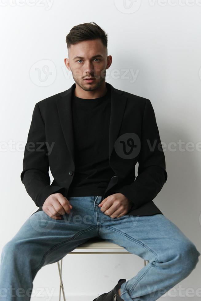 Modelling snapshots. Serious narcissistic self-confident attractive handsome man in classic suit sit on chair posing isolated in white studio background. Fashion offer. Copy space for ad photo