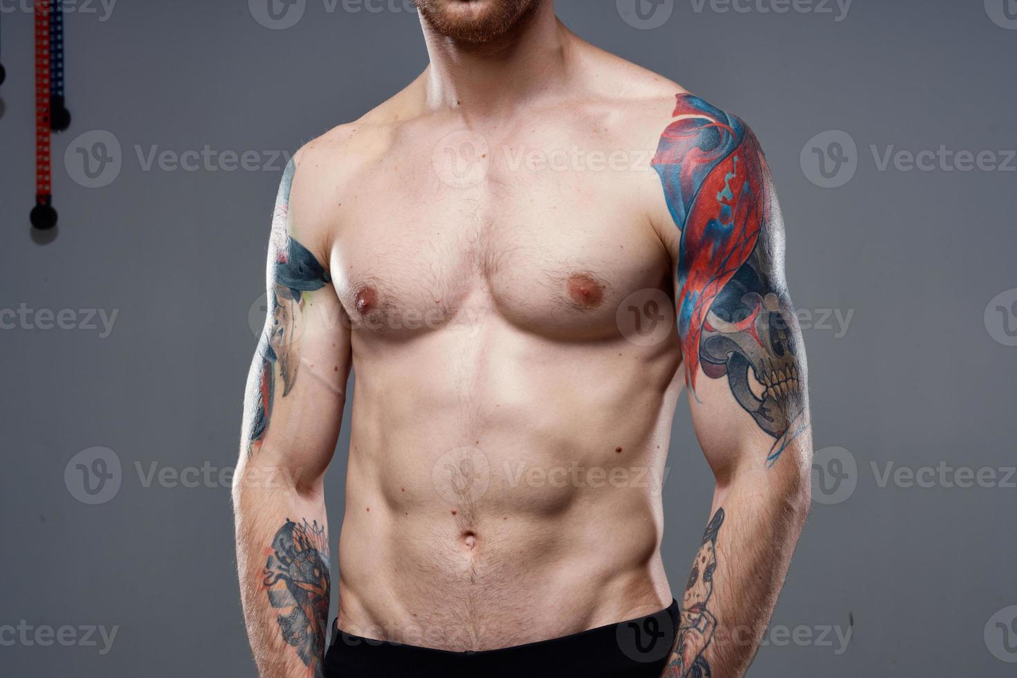 hombre con tatuajes en su brazos desnudo torso bombeo arriba abdominales rutina de ejercicio foto