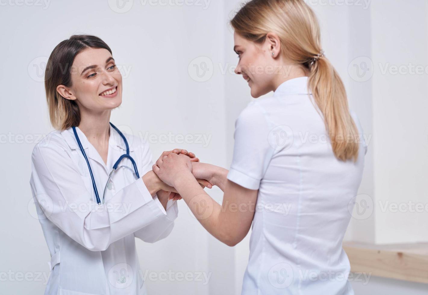 professional doctor nurse shakes hands with a patient and a stethoscope around her neck photo