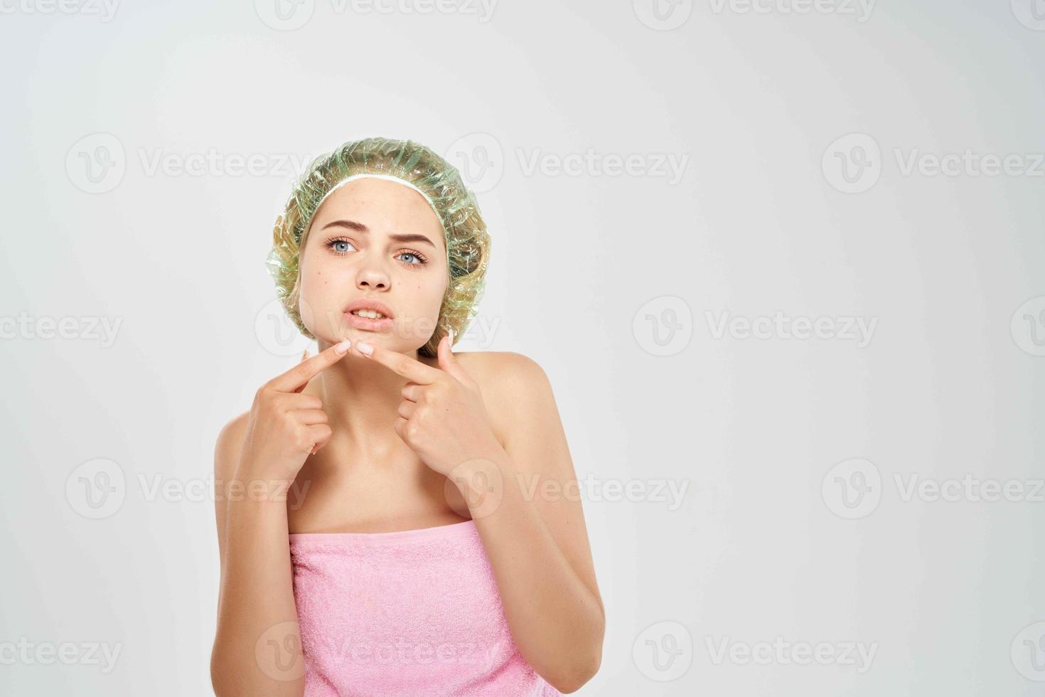 woman shower cap squeezes acne on face skin care photo