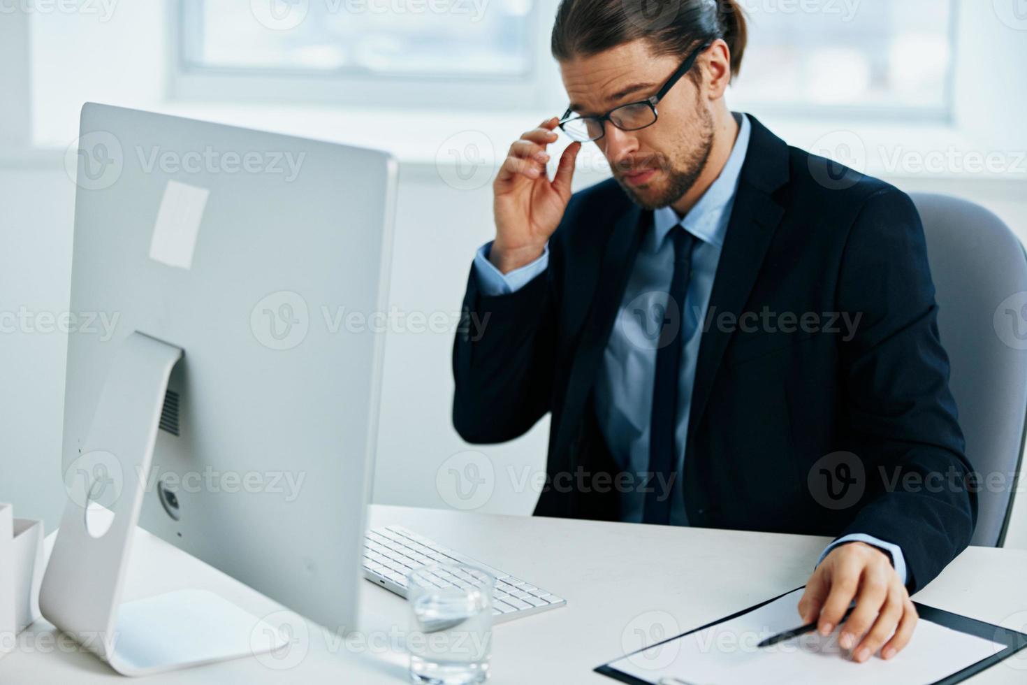 man in a suit sitting at a desk in front of a computer Chief photo