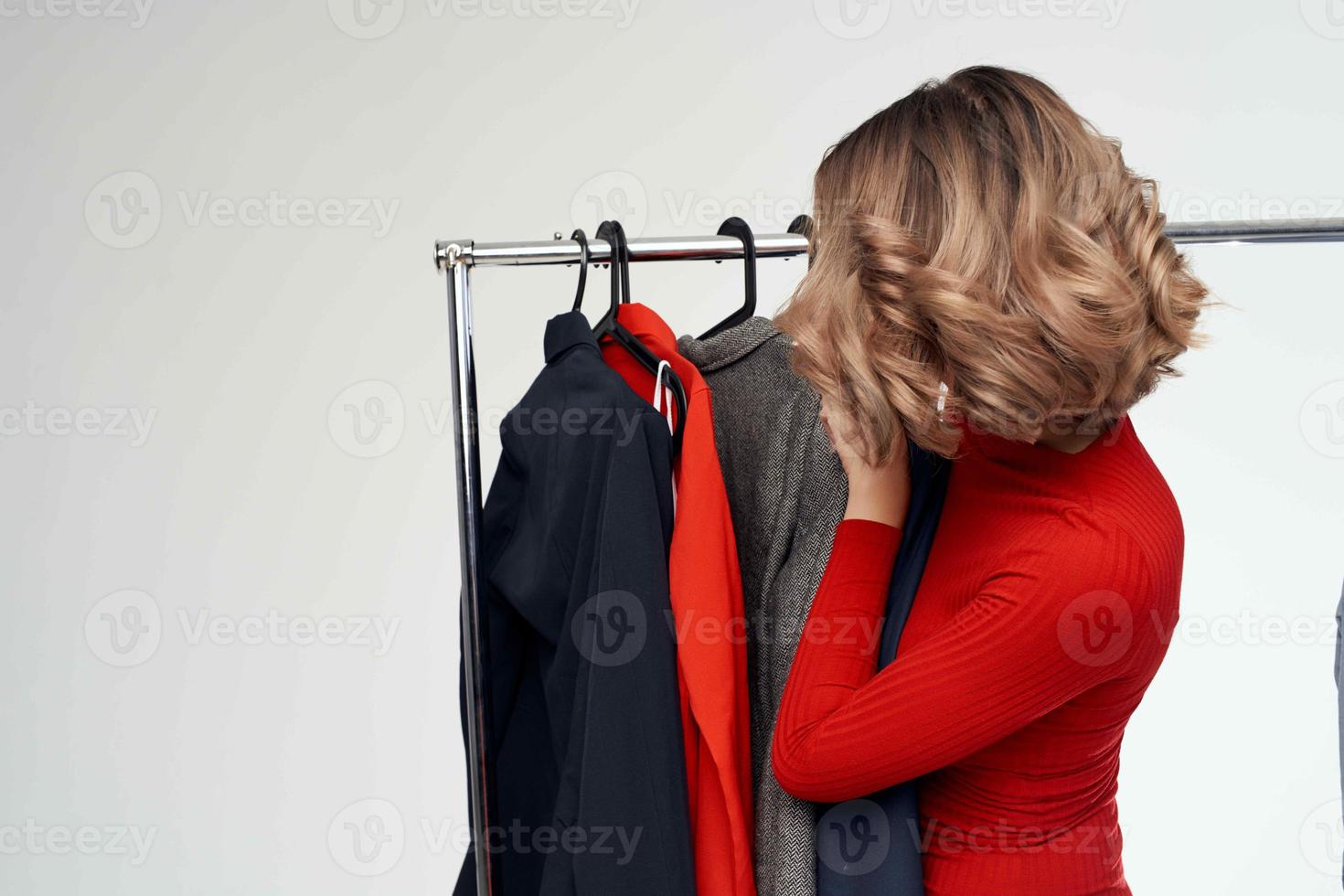 bonito mujer en un rojo chaqueta cerca el guardarropa Al por menor emociones foto