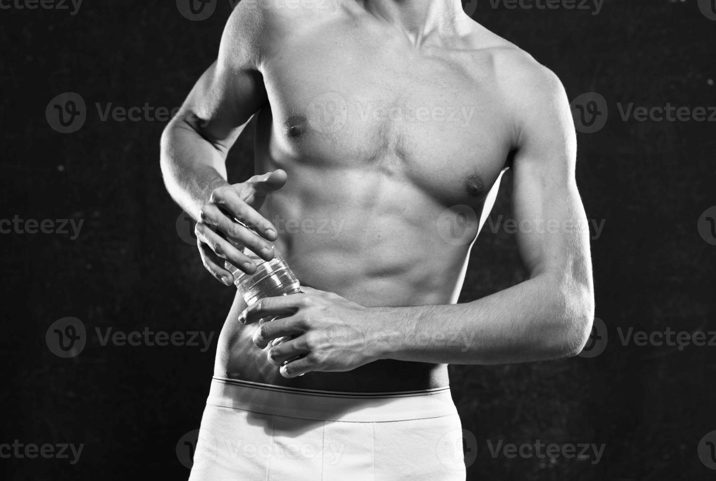 male athlete in white shorts inflated body bodybuilder the dark background photo