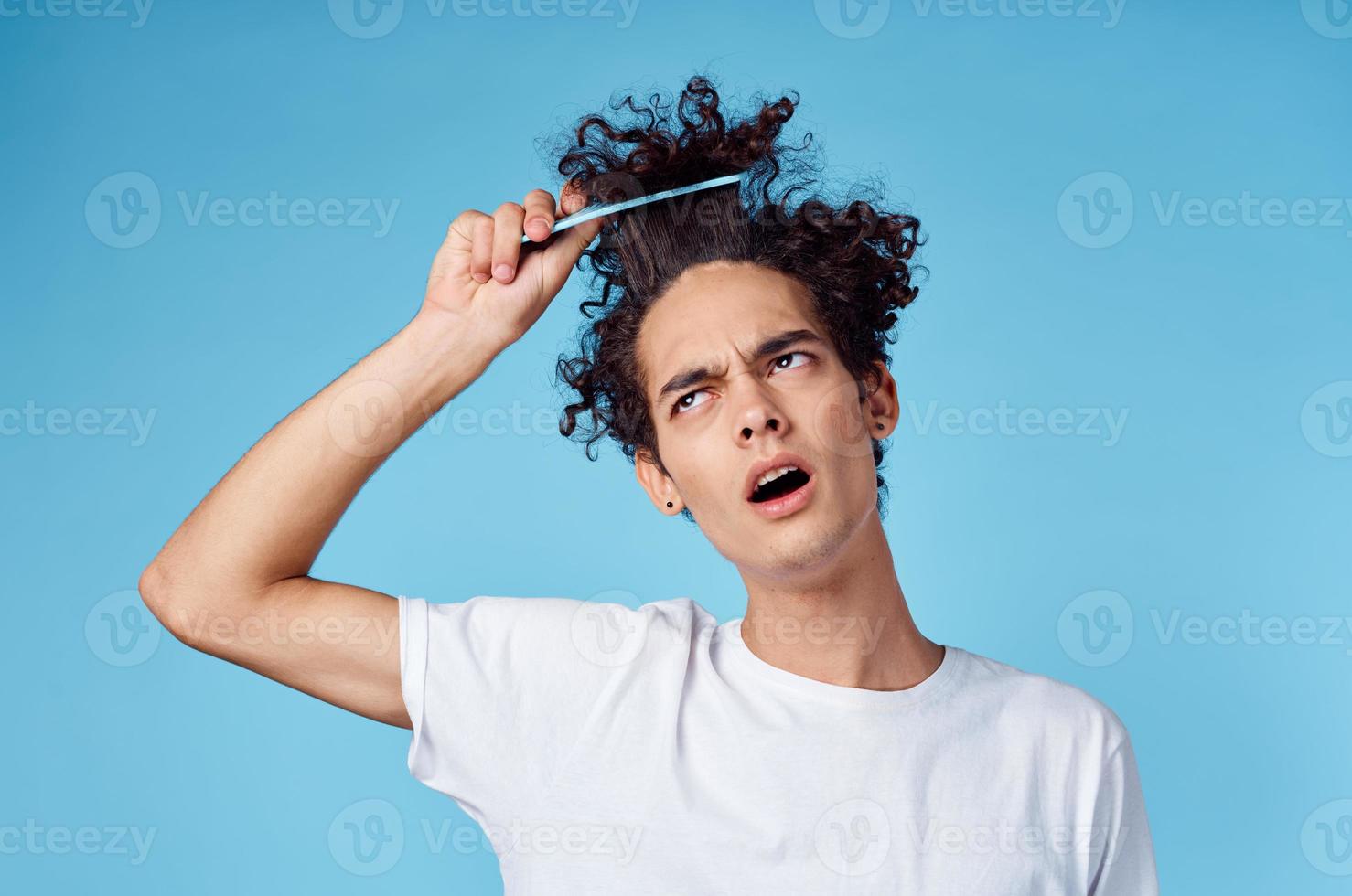 a man in a white t-shirt curly hair stuck comb emotions photo