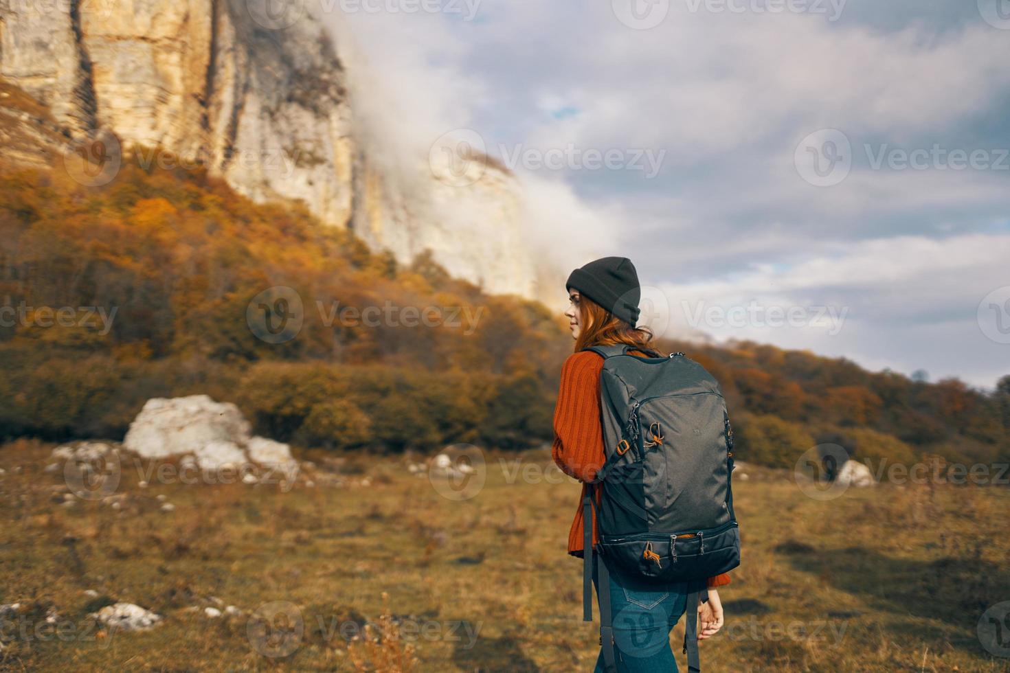 woman in a sweater with a backpack walks in the autumn in the mountains outdoors recreation model vacation photo
