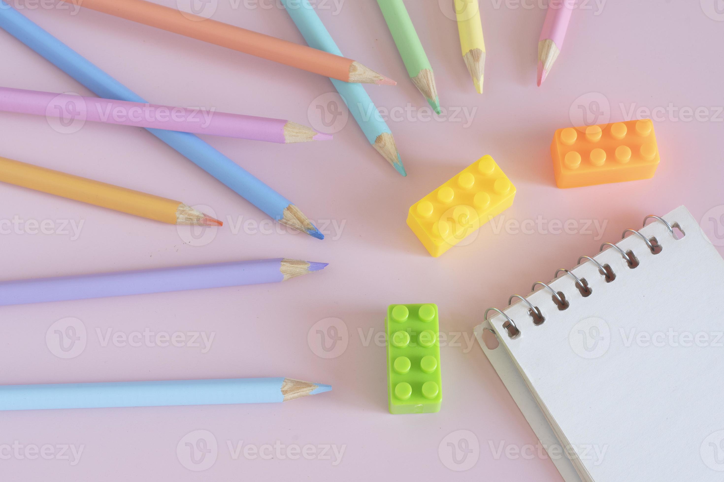 Pastel colored pencils, top view on pink background, illustration