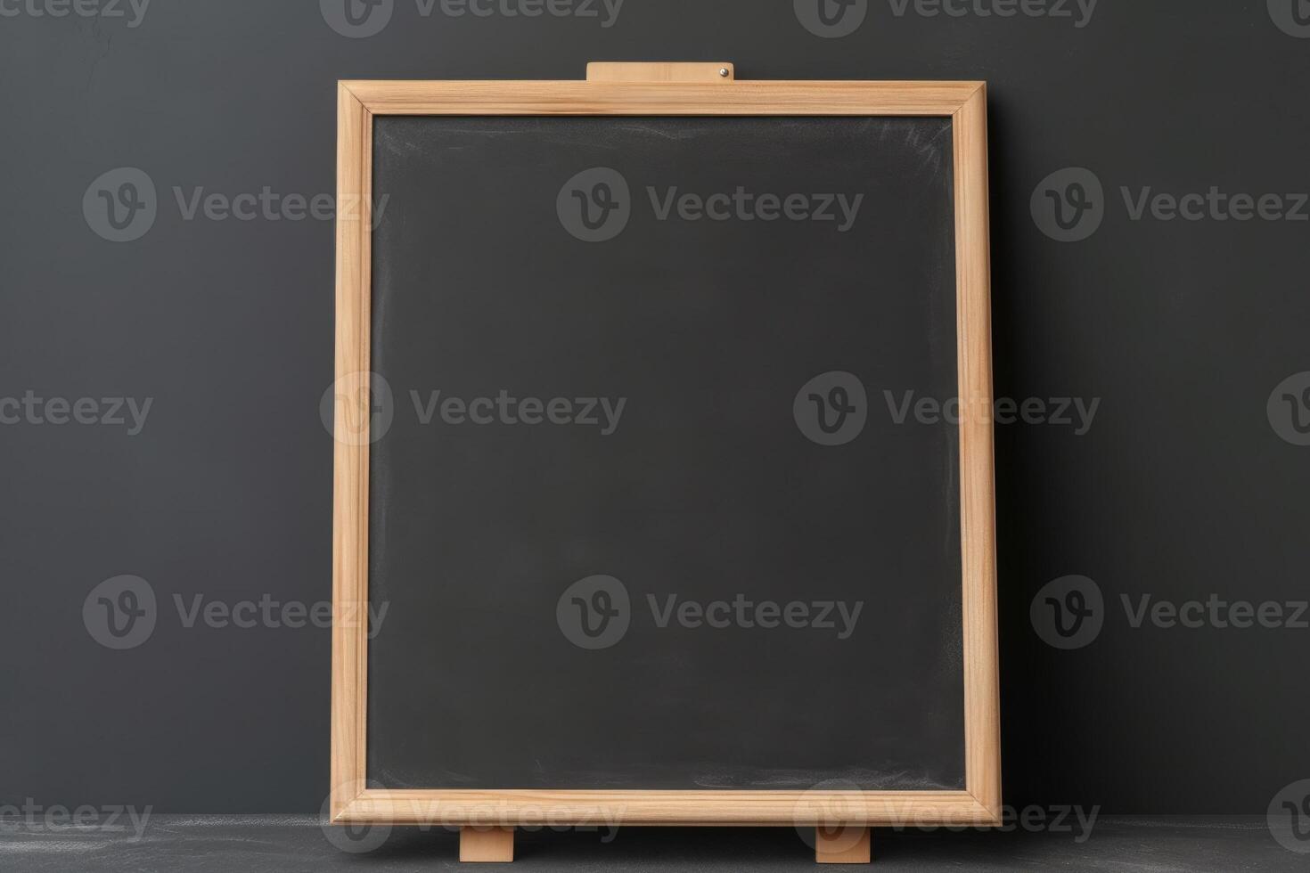 Illustration of a blackboard with a wooden frame against a gray wall created with technology photo
