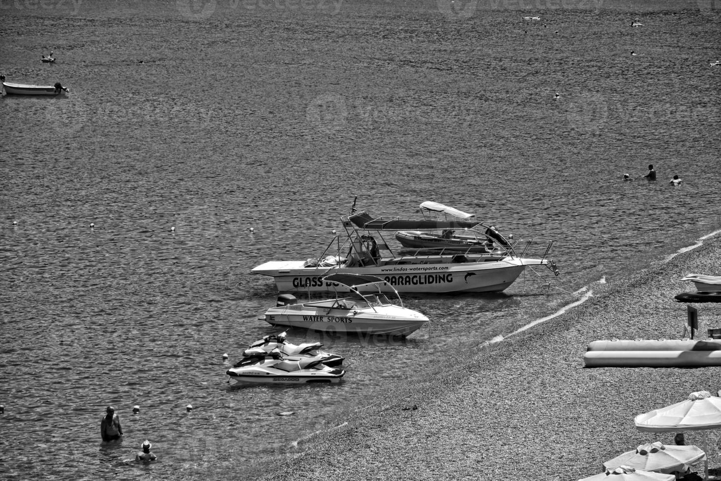 beach on the Greek island of Rhodes with blue water and a strip on a hot summer's vacation day photo