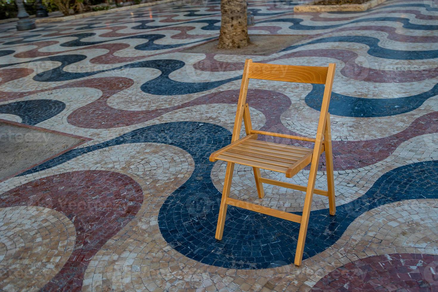 Explanada promenade in Alicante Spain landmark with wooden empty chair on mosaic photo