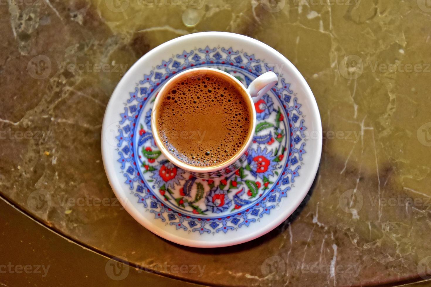 hot aromatic sweet black Turkish coffee in a small colorful cup photo