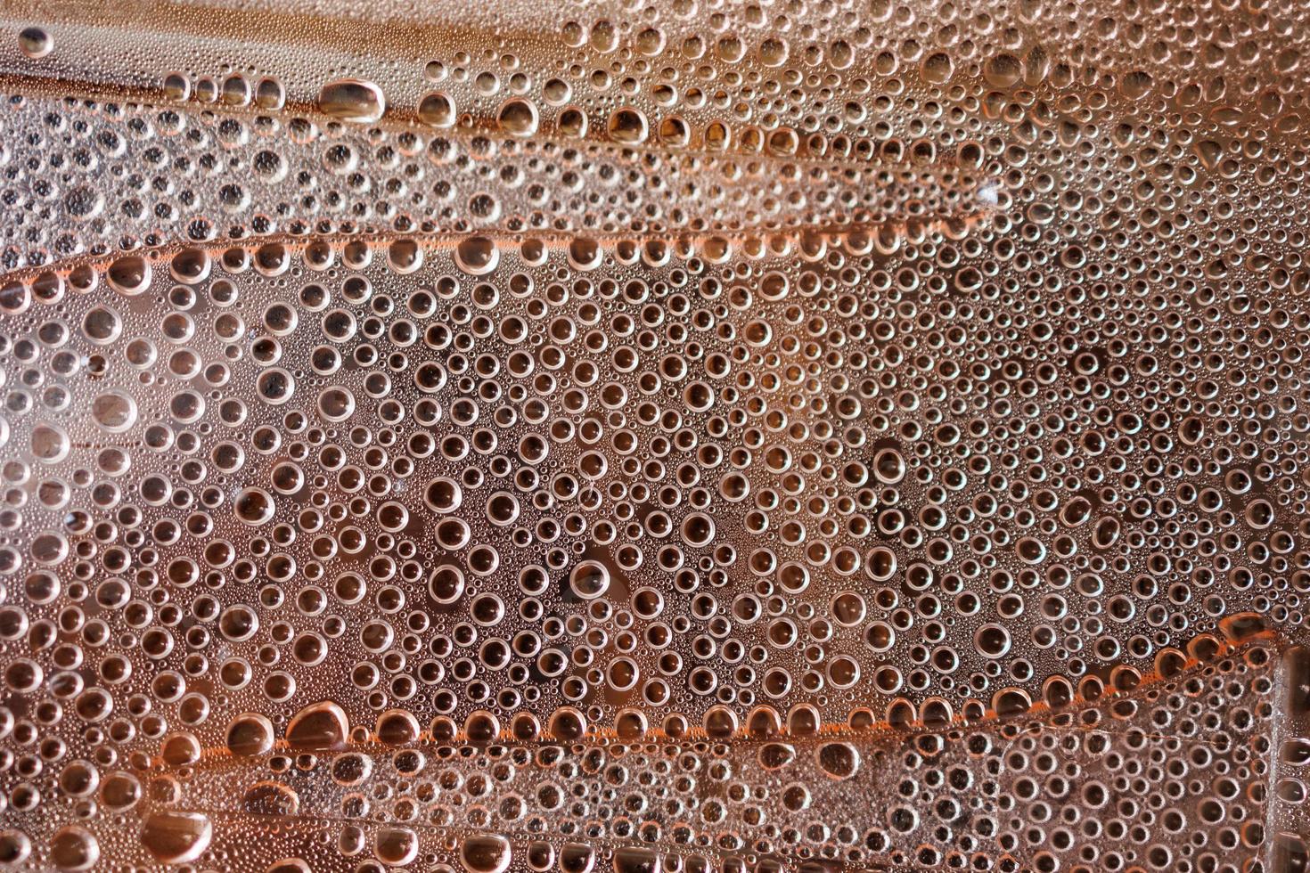 small drops of water on a beige background in close-up photo