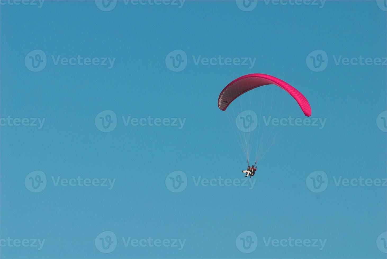 paragliders in the blue cloudless sky photo