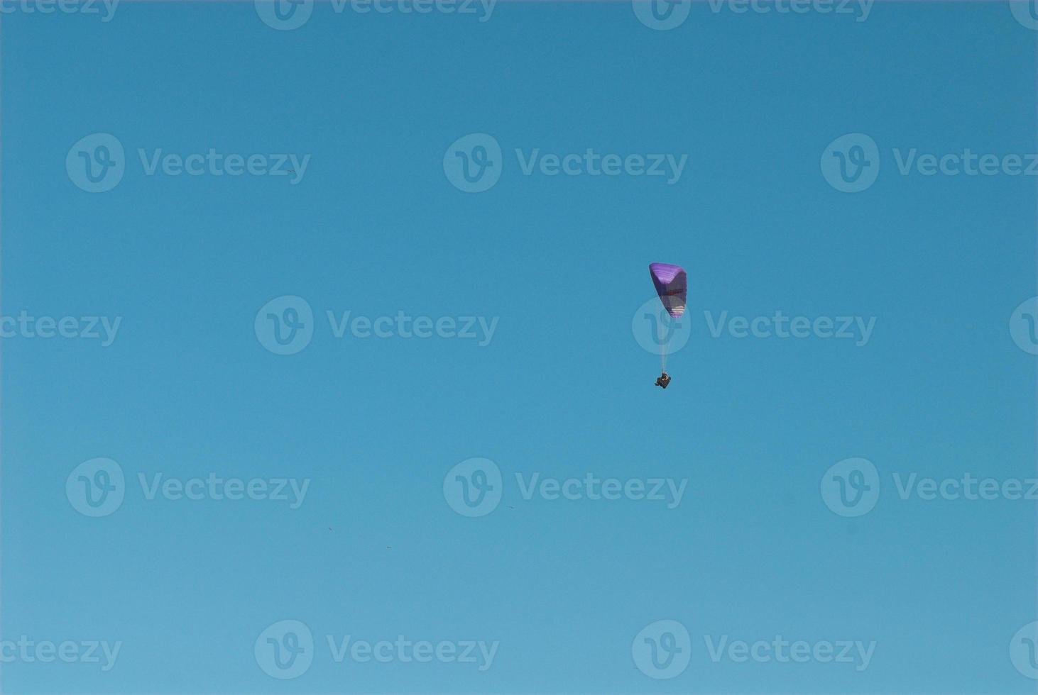 paragliders in the blue cloudless sky photo