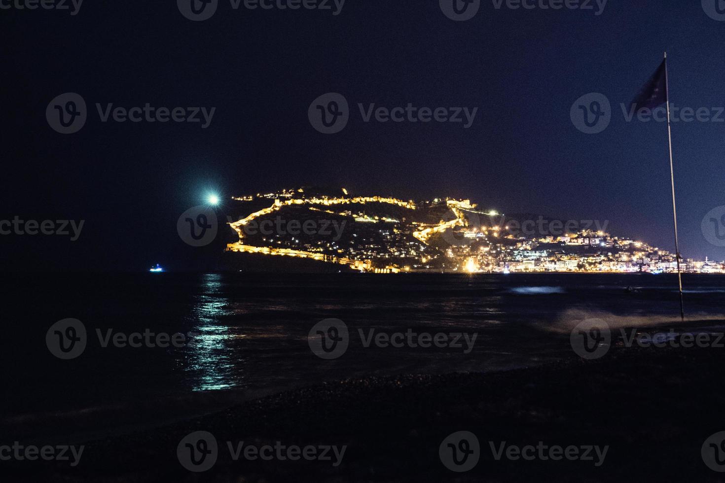 night view of the turkish city of alanya with lights on the hill photo