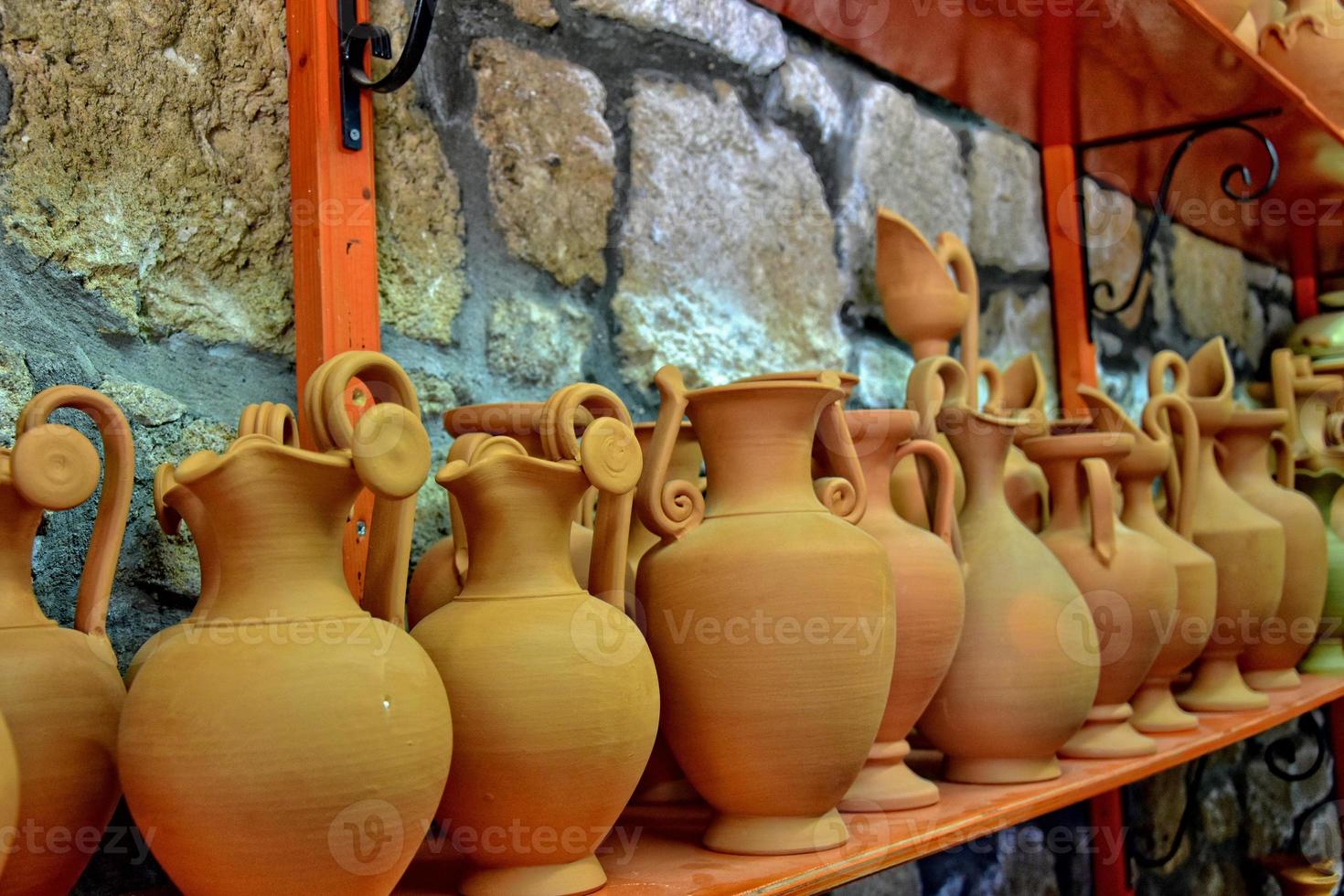 handmade clay dishes in the Greek style in the shop at the potter's workshop photo