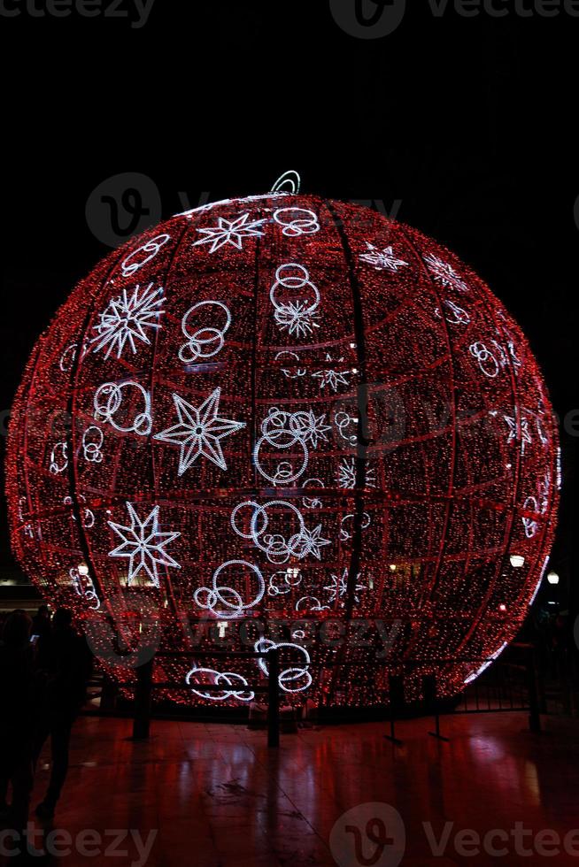big glowing red bauble Christmas decoration in Alicante, Spain at night photo