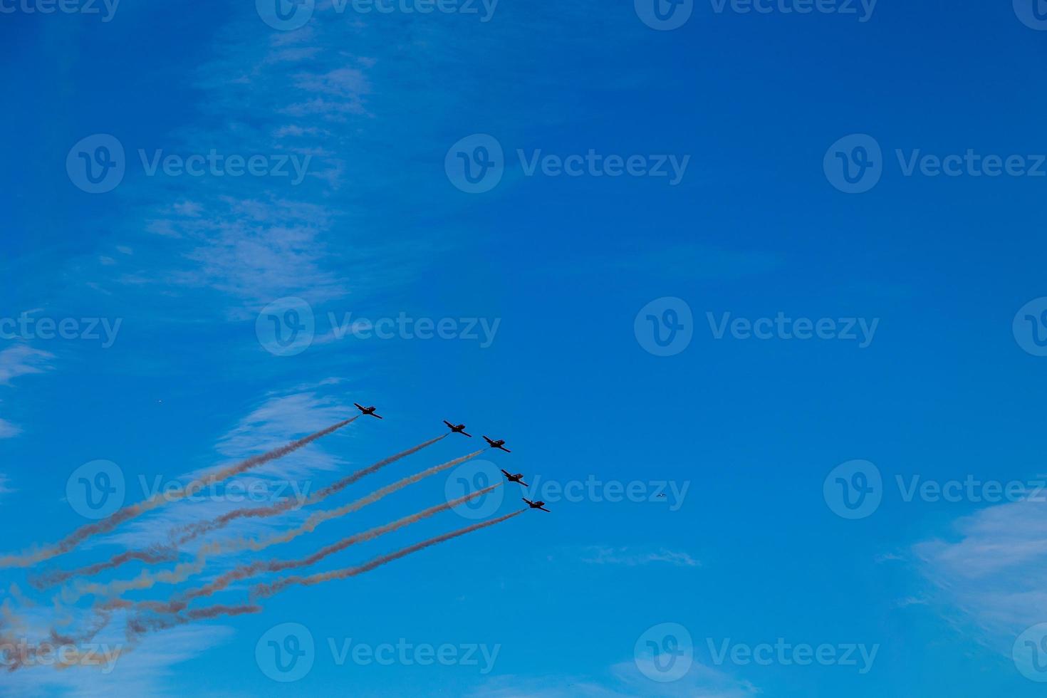 flight of five cessna planes over alicante smoke spanish flag against the blue sky photo