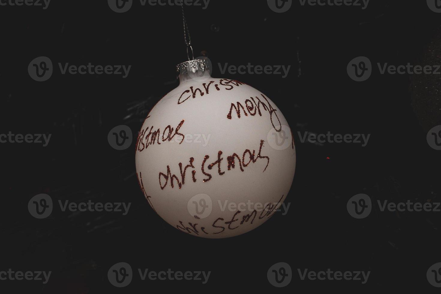 white bauble with red inscription merry christmas on a festive background photo