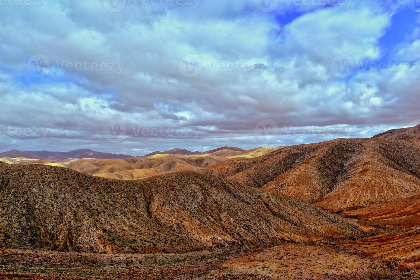 empty mysterious mountainous landscape from the center of the Canary Island Spanish Fuerteventura with a cloudy sky photo