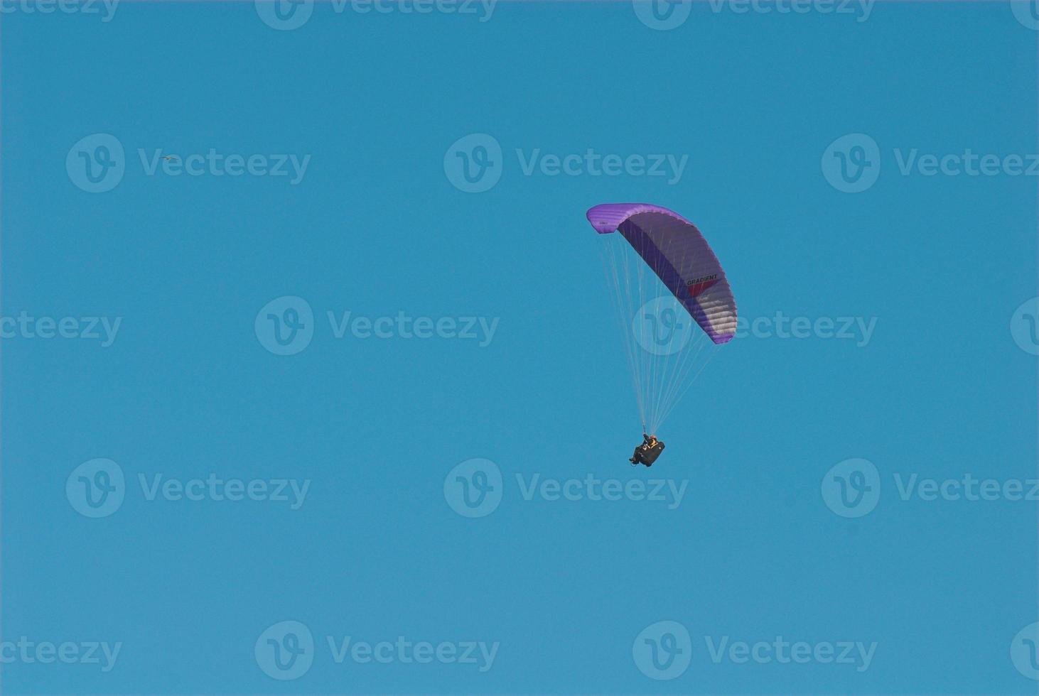 paragliders in the blue cloudless sky photo