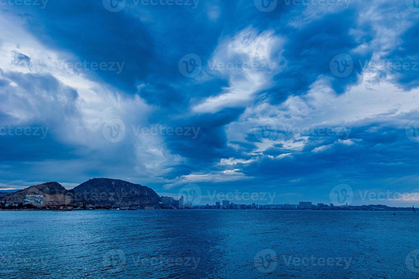 seaside landscape with clouds and sailboat on the horizon Alicante Spain photo