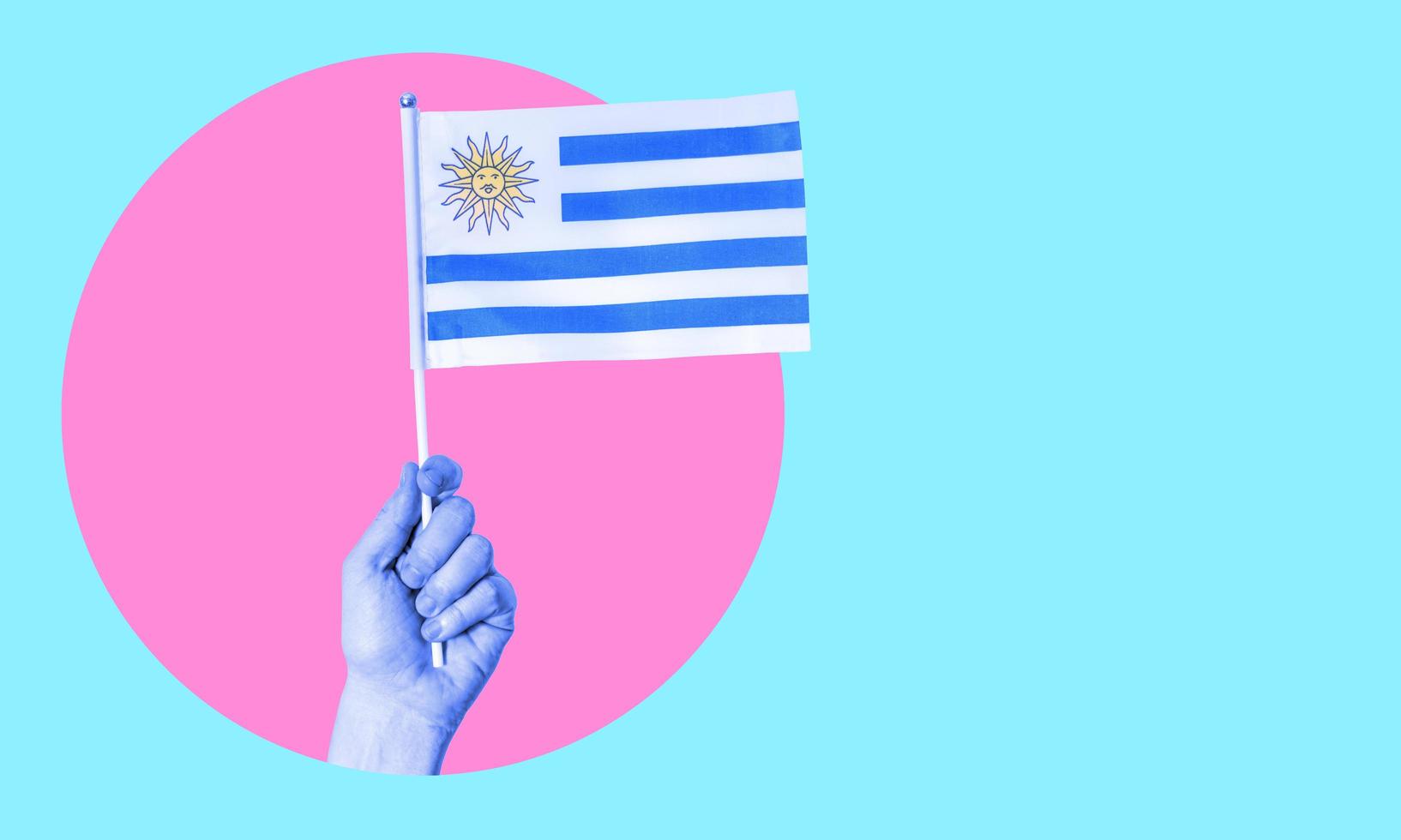 A collage of modern art. Female hand holding the flag of Uruguay in a circle, neon background, with space for text. photo