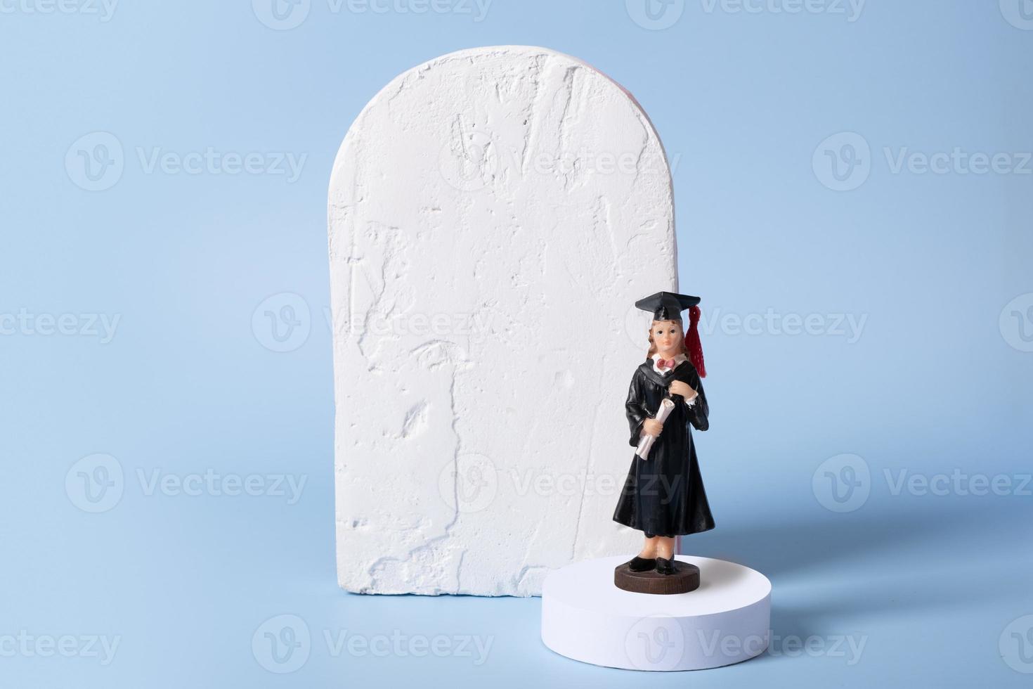 A statuette of a graduate on a podium with a mock-up of a cement board for a text class photo