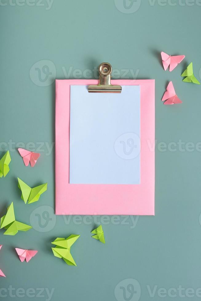 Massage board mockup with paper butterfies green and pink color flat lay on a colored background photo