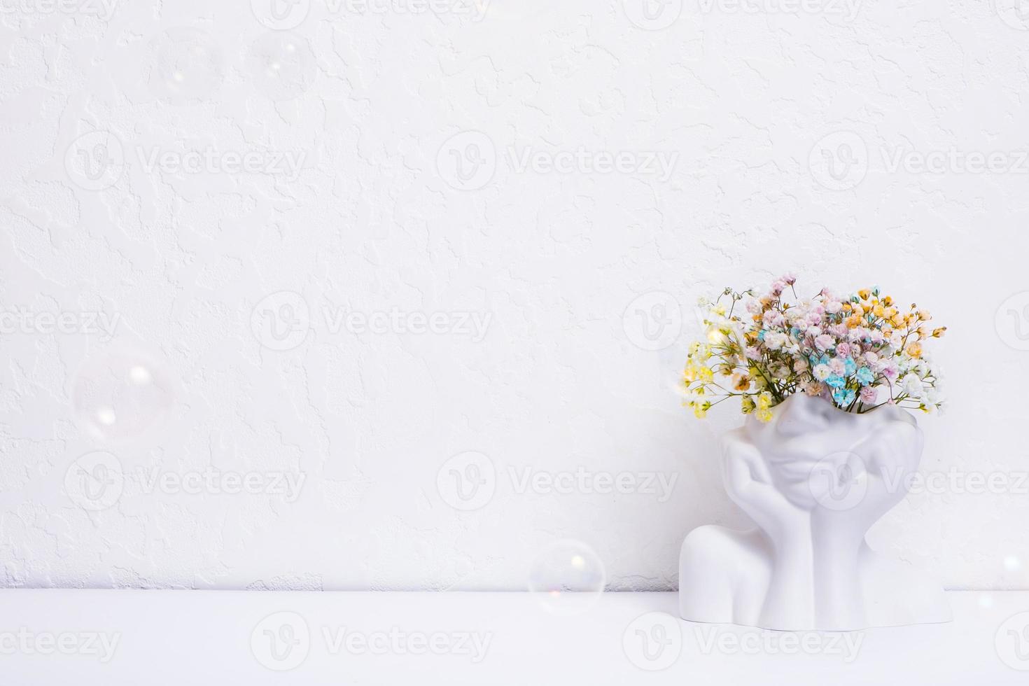 Concept of mental health. Flowers in a vase with a woman's head and soap bubbles. Copy space. photo