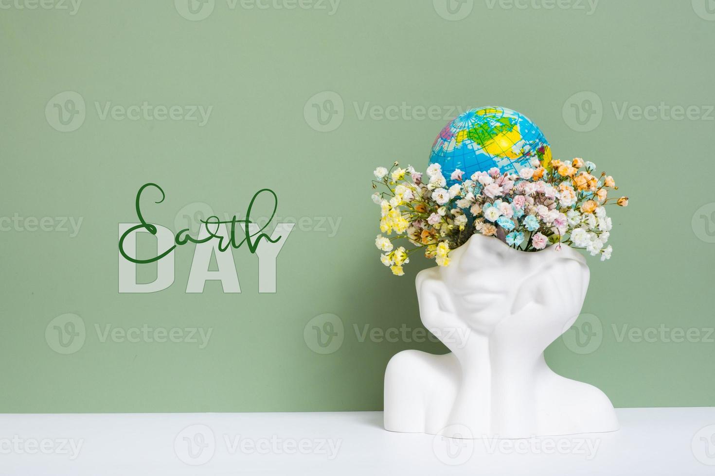 Creative plaster vase head-shape with flowers and world globe. Save the planet, Earth day concept photo