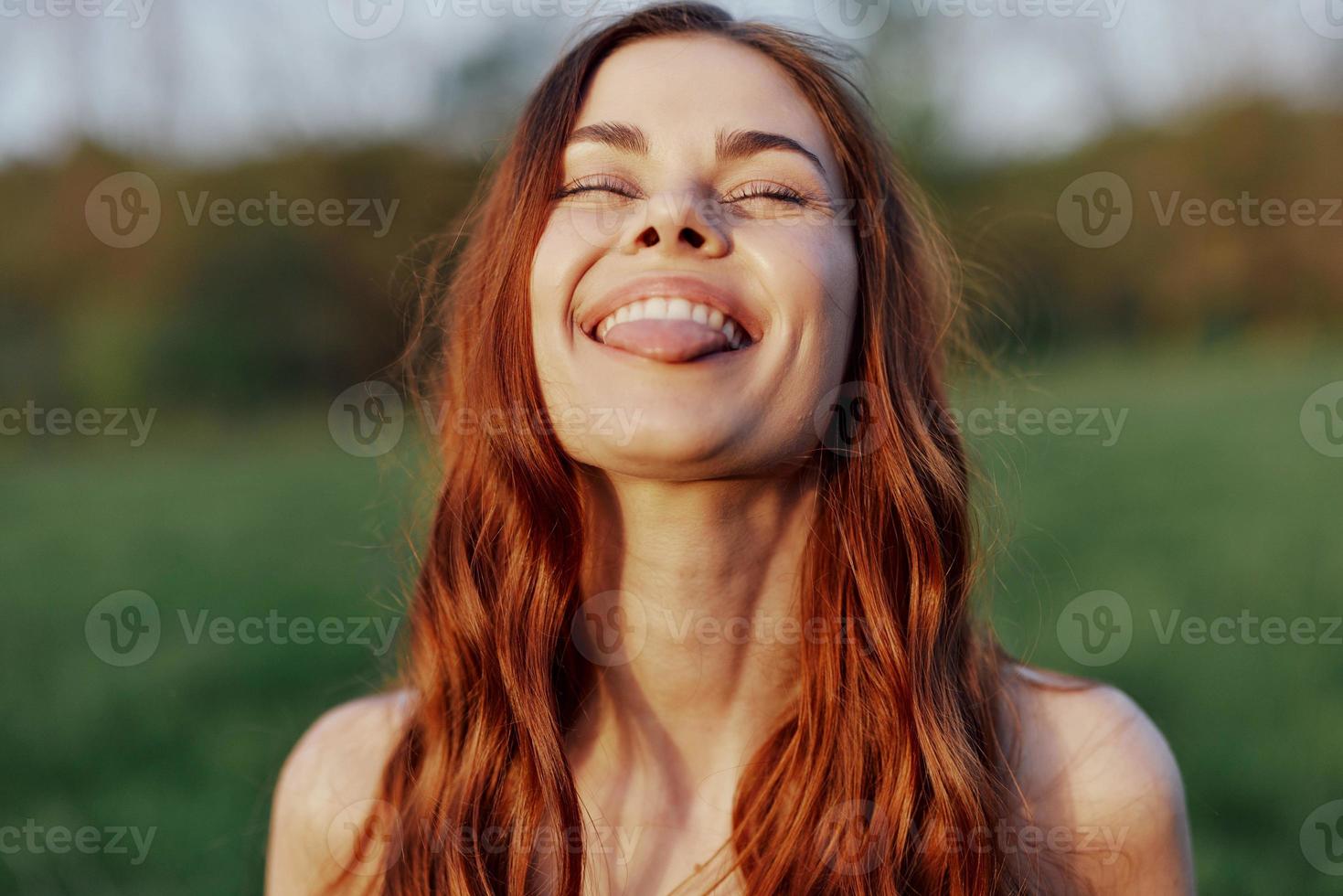 Woman smiling beautiful with red hair close-up portrait looking at camera photo