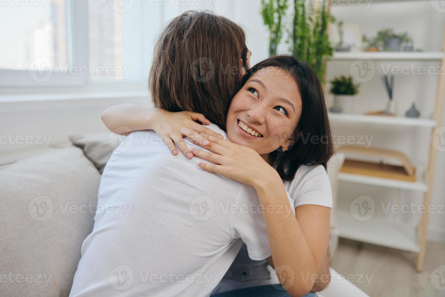 An Asian woman hugs her husband and smiles. The joy of using the family and the good psychological state after the quarrel photo