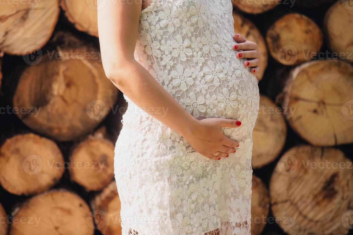 pregnant woman in a beautiful dress. Focus on the abdomen. photo