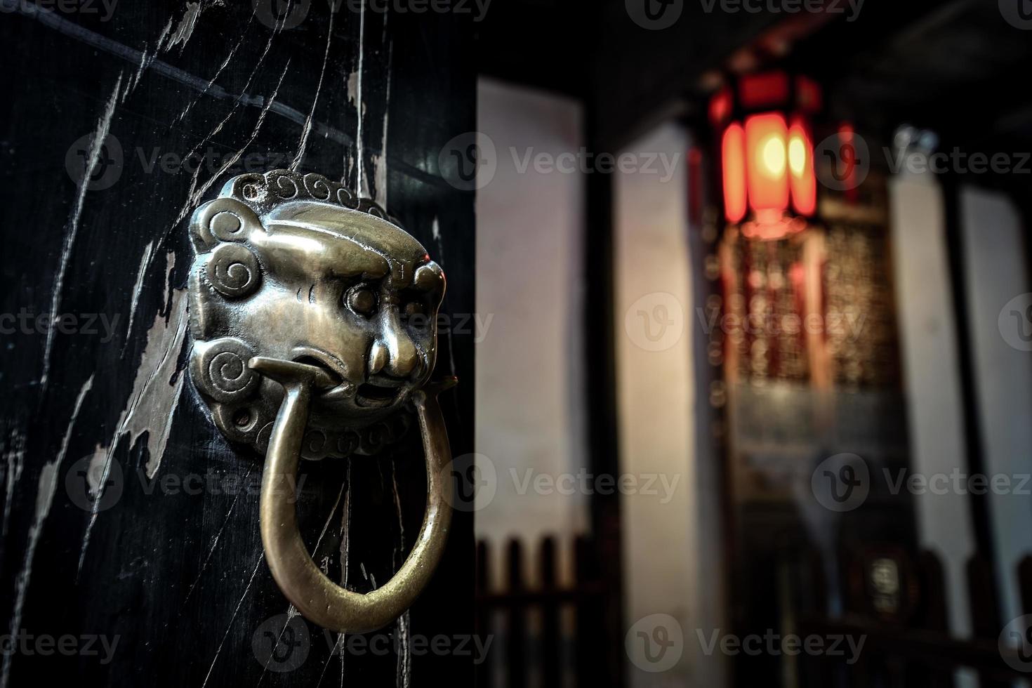 Traditional lion shape door knocker in old house in ancient Chinese town photo