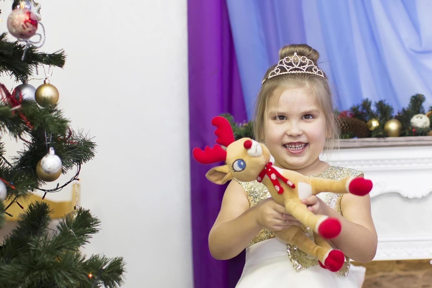Belarus, the city of Gomil, December 27, 2018. Morning party in kindergarten.Funny child with a toy by the Christmas tree in kindergarten. photo
