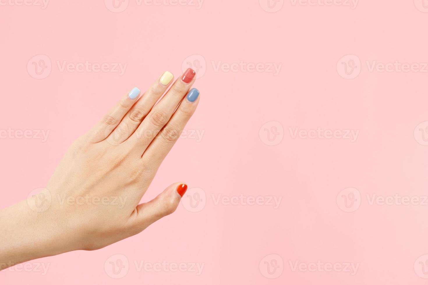 Beautiful female hand painting acrylic gel nails. Fashion style. Pink background. photo