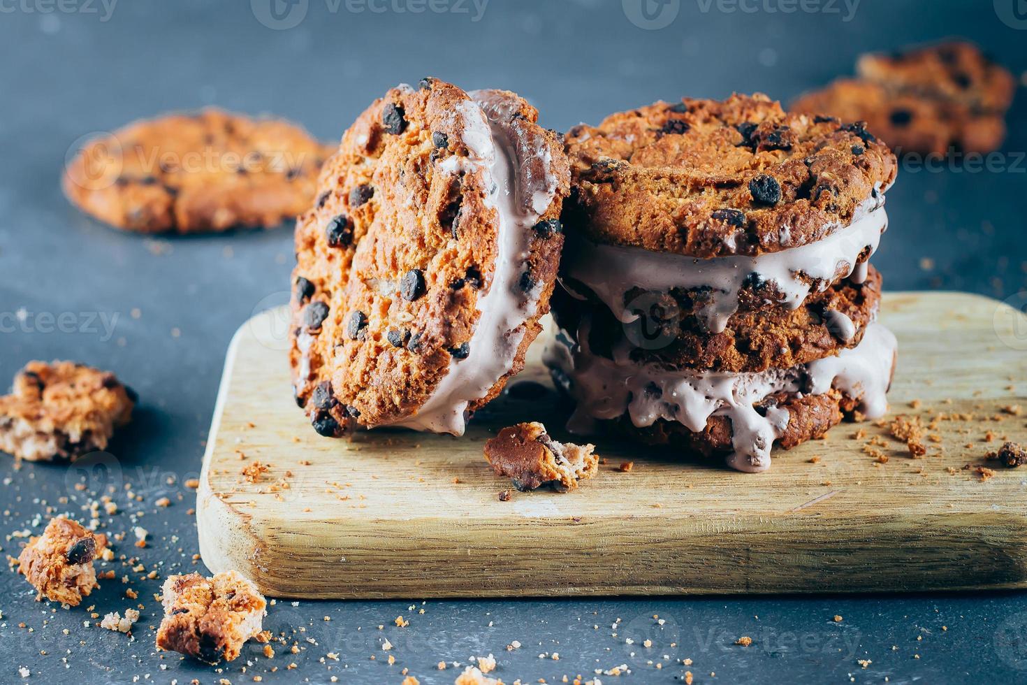 chocolate hielo crema emparedados y chocolate chip galletas en de madera tablero foto