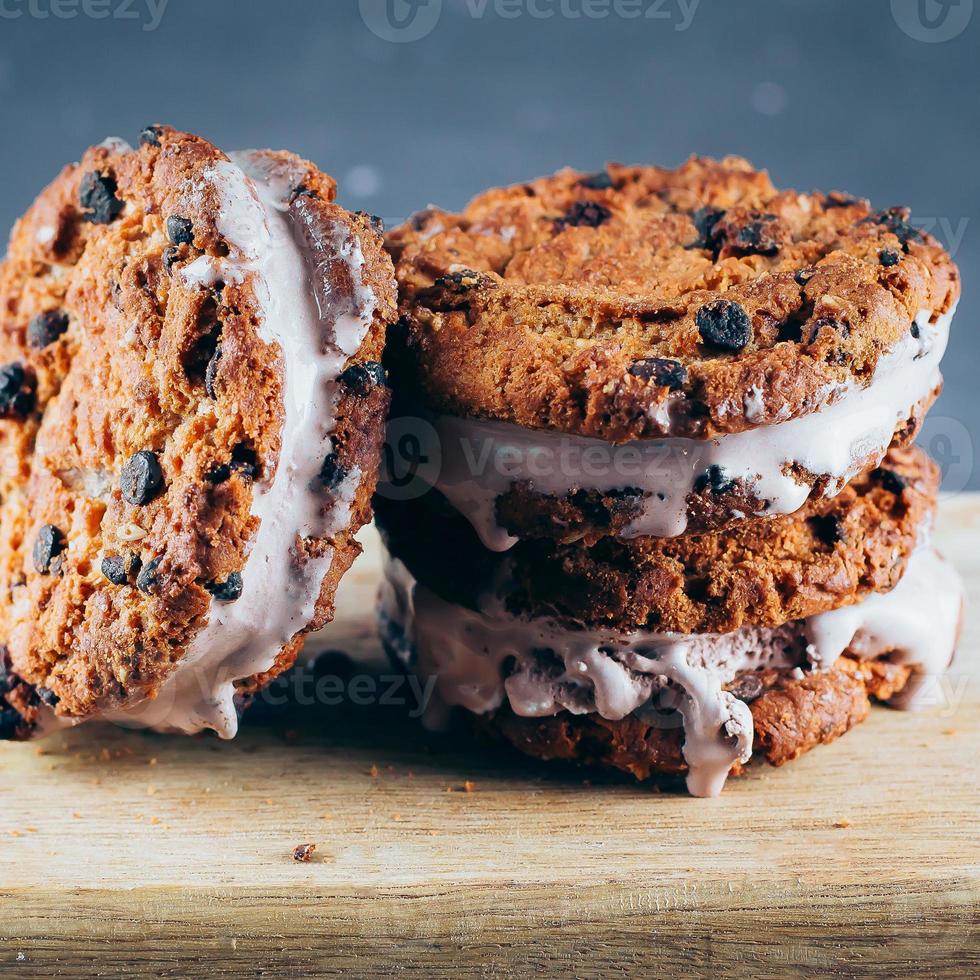 Chocolate Ice cream sandwiches and chocolate chip cookies on wooden board photo