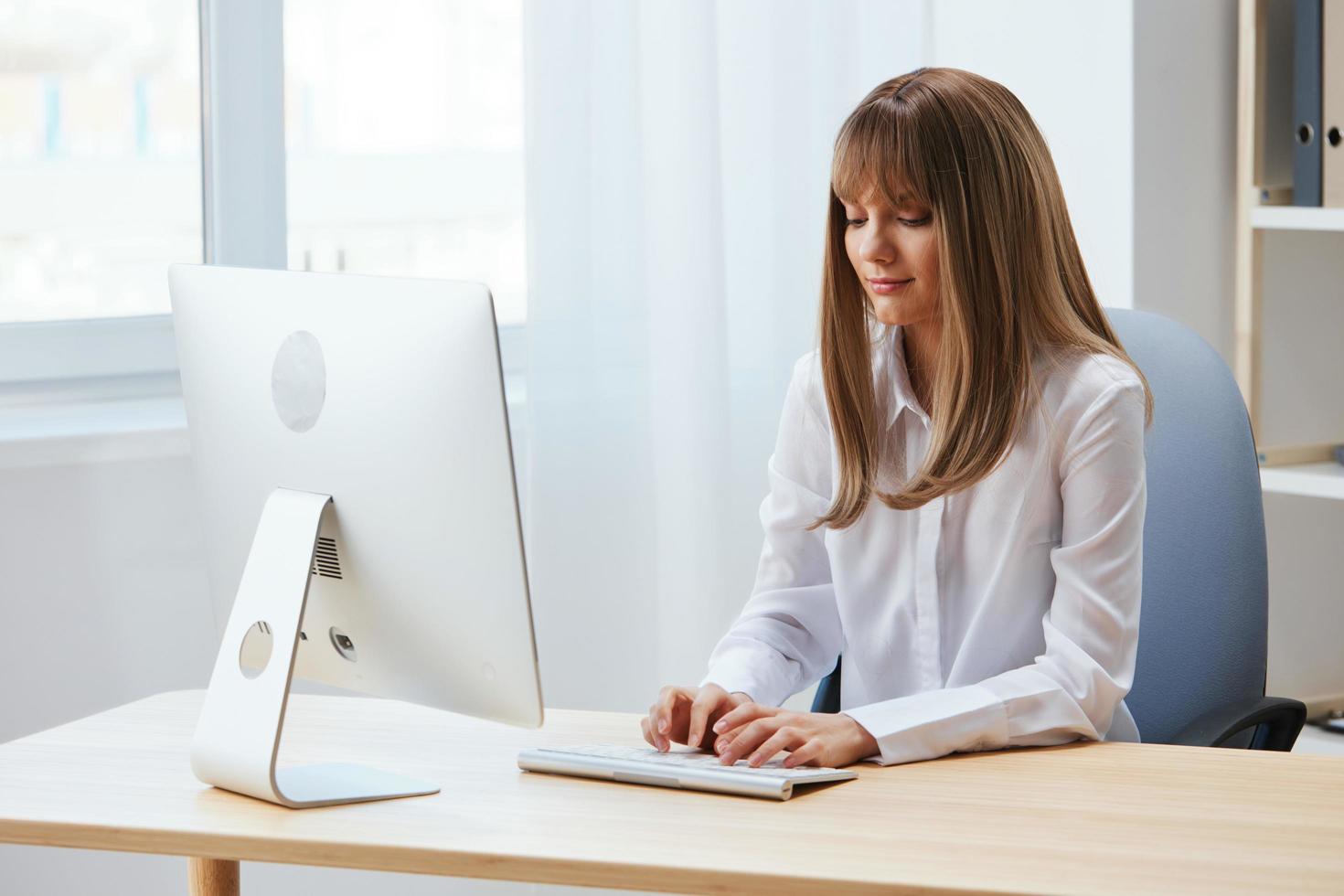 Focused adorable blonde businesswoman worker freelancer look at keyboard thinking of problem solution in light modern office. Employee work on computer online pondering or making decision. Copy space photo