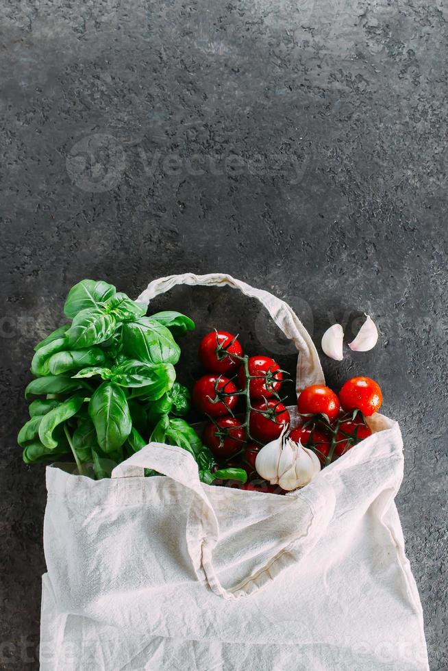 sano producto para italiano pasta en tela bolso en oscuro mesa. reutilizable bolso con comestibles. foto
