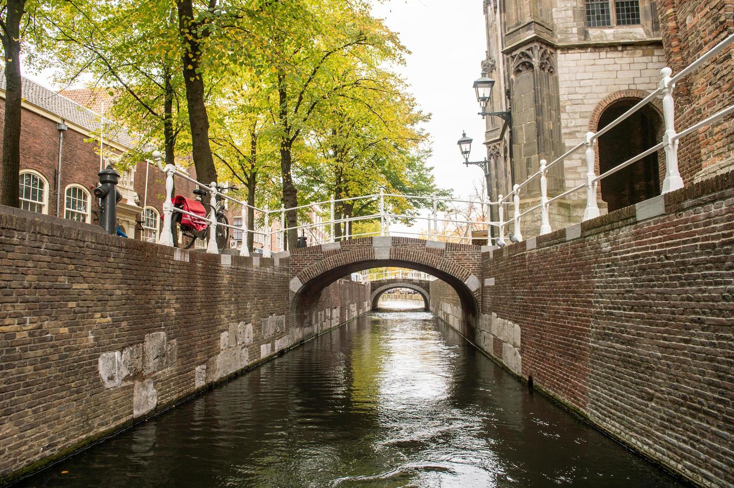 The Netherlands, Delft, October 2022. The narrowest canal in Delft. Two old bridges photo