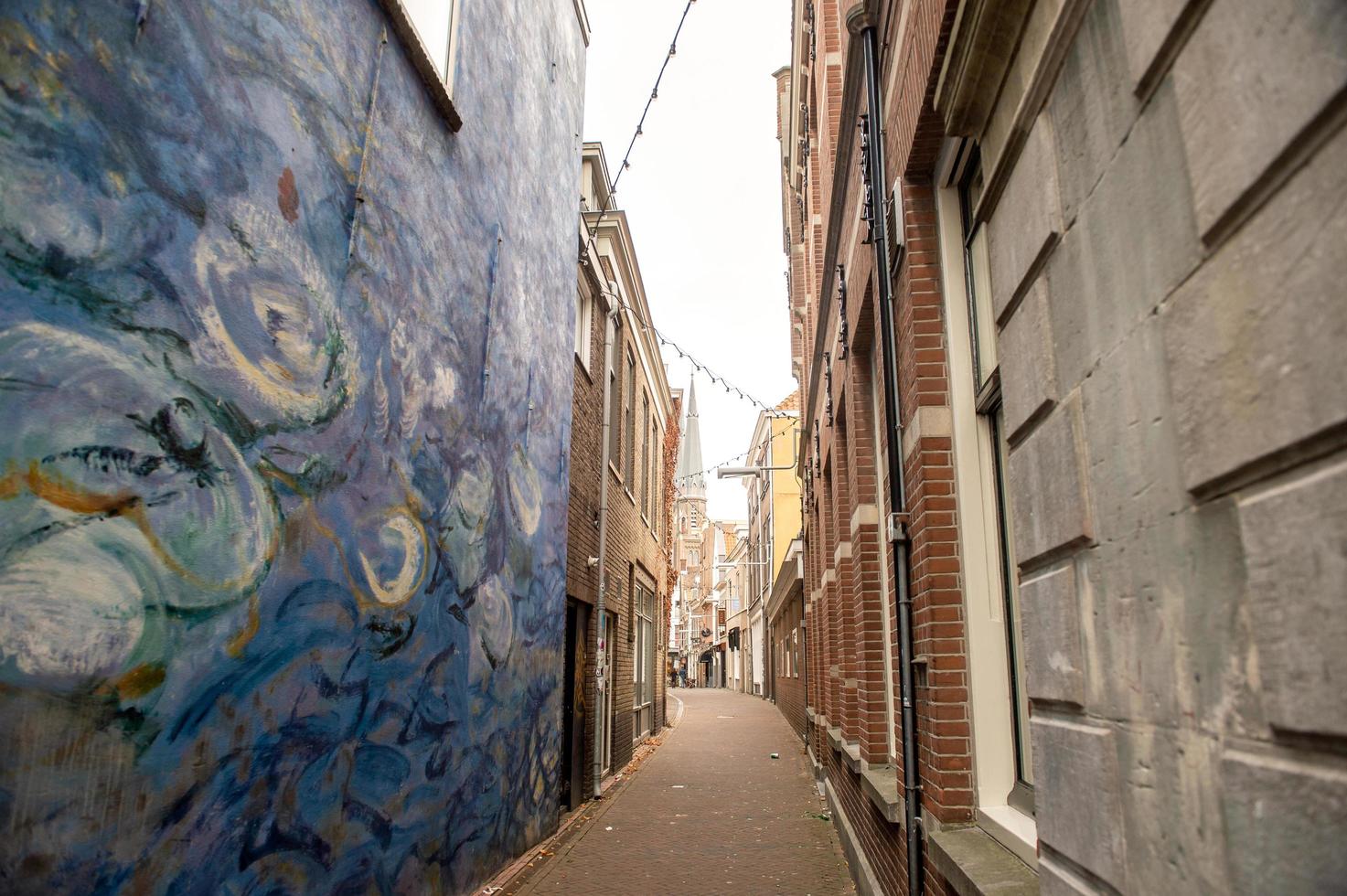 The Netherlands, Delft, 2022. Narrow street in Delft, walled with van Gogh painting emanation photo