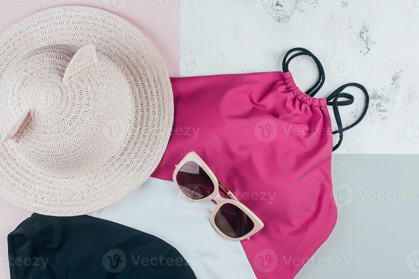 Woman's beach accessories one piece swimsuit, sunglasses and hat on background photo